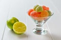 Colorful marmalade in a glass bowl and lime on a white wooden table Royalty Free Stock Photo