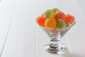 Colorful marmalade in a glass bowl on a white wooden table Royalty Free Stock Photo