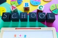 Colorful math fractions on the green, yellow, purple background. Blocks with title School on the table. Interesting, fun math Royalty Free Stock Photo