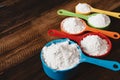 Colorful measuring cups with flour on wooden table