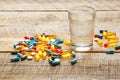 Colorful medical pills with water on wodden table Royalty Free Stock Photo