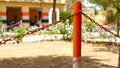 Colorful metal bollards with colorful iron chain closeup. Stand chain barrier closeup with iron linked chain