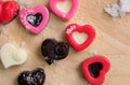 Colorful milk chocolates heart on wooden plate and snow.