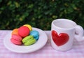 Colorful mini macarons with love mug