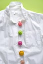 Colorful mini macarons on white shirt imitating buttons