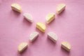 Colorful mini marshmallows on pink background, closeup. Fluffy marsh mallows texture and pattern.