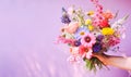 Colorful Mixed Bouquet Held in Hand Against Pink Background. Flower present. Summer garden bouquet Royalty Free Stock Photo