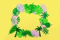 Colorful monstera, palm and flamingo leaves on yellow background