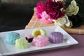 Colorful Mooncake on Plate with Flowers on Background