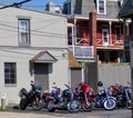 Colorful motorcycles parked in front of gray building. Royalty Free Stock Photo