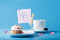 Colorful muffin on saucer with flower petal and message Royalty Free Stock Photo