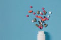 Multicolored Pills And White Bottle On Blue Background, Top View. Medicine Healthcare Pharmacy Concept Royalty Free Stock Photo