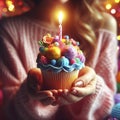 Colorful multicolored cupcake with candle in female hands. Festive birthday greetings. ai generative