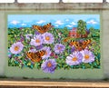Colorful Mural Of House Surrounded by Flowers and Butterflies On James Road in Memphis, Tennessee.