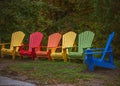 Colorful Muskoka chairs. Fall wallpaper. Rainbow colours furniture. Royalty Free Stock Photo