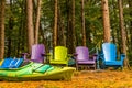 Colorful wooden chairs at rivers edge in the colors of Autumn, w Royalty Free Stock Photo