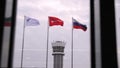 Colorful national and corporative flags against grey sky