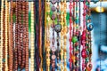 Colorful necklaces at outdoor small souvenir shop in Italy. Decorative colorful crystal chaplets