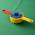 Of colorful nested plastic measuring cups displayed on a green Royalty Free Stock Photo