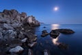 Colorful night landscape with full moon, lunar path and rocks in summer. Mountain landscape at the sea. Royalty Free Stock Photo