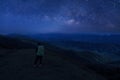 Colorful night sky with stars and silhouette of a standing man on the stone. Blue milky way with man on the mountain. High Rocks. Royalty Free Stock Photo