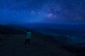 Colorful night sky with stars and silhouette of a standing man on the stone. Blue milky way with man on the mountain. High Rocks. Royalty Free Stock Photo