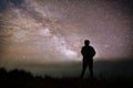 Colorful night sky with stars and silhouette of a standing man on the stone. Blue milky way with man on the mountain. Royalty Free Stock Photo