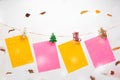 Colorful note papers hanging rope with mini Christmas wooden clamps on winter fall leaves background Royalty Free Stock Photo