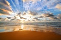 Colorful ocean beach sunrise with deep blue sky and sun rays Royalty Free Stock Photo