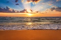 Colorful ocean beach sunrise with deep blue sky and sun rays