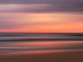 Colorful ocean sunset with long exposure effect. Motion blurred. Orange and purple background