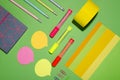 Top view of bright and colorful notebook, pencils, tape, notes paper, markers, paper on the green desk Royalty Free Stock Photo