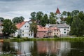 Colorful old town houses and church with lake reflection in cloudy summer day. Royalty Free Stock Photo