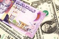 A colorful Omani riyal bank note on one dollar bills Royalty Free Stock Photo