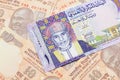 A colorful Omani riyal bank note on one dollar bills Royalty Free Stock Photo