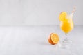 Colorful orange cool citrus cocktail with slice oranges, ice cube, straw on white modern wooden background. Royalty Free Stock Photo