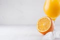 Colorful orange cool citrus cocktail with slice oranges, ice cube, straw on white modern wooden background, closeup. Royalty Free Stock Photo