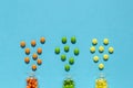 Colorful, orange, green, yellow pills spill out of the transparent bottle on the blue background. Royalty Free Stock Photo