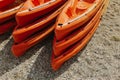 Colorful orange kayaks on a sandy beach in sunny day