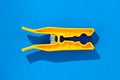 Orange clothes peg on blue backgournd Royalty Free Stock Photo