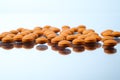 Colorful orange pills on reflective surface Royalty Free Stock Photo