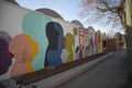 a colorful orange, yellow, blue and pink wall mural with silhouettes of people and the words Be Love at the King Center in Atlanta