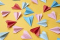 Colorful origami paper airplanes on yellow colored background