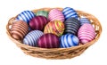 Colorful ornate Easter eggs pile in wicker basket isolated on white background