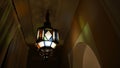 Colorful ornate Moroccan style lamp illuminating the corridor of a small hotel in the Medina of Marrakesh, Morocco at night.