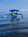 Colorful outrigger boat with tranquil scene on shallow beach Royalty Free Stock Photo