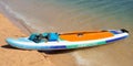 A colorful paddle board pulled up on the sandy beach at Lake Powell