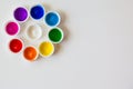 Colorful paint bottles caps on white paper background with copy space, top view/arts and crafts background concept Royalty Free Stock Photo
