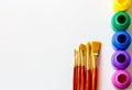 Colorful paint bottles and paint brushes on white background with copy space, top view/arts and crafts background concept Royalty Free Stock Photo