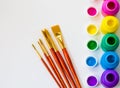 Colorful paint bottles and paint brushes on white background with copy space, top view/arts and crafts background concept Royalty Free Stock Photo